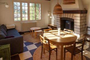 - un salon avec une table et une cheminée dans l'établissement Maison avec vue sur Loire proche de Chambord, à Saint-Dyé-sur-Loire