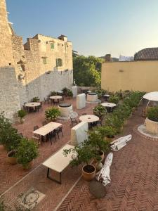 an outdoor patio with tables and chairs and plants at TheRoom in Šibenik