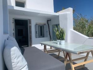 eine Terrasse mit einem Tisch und einer Bank auf einem Balkon in der Unterkunft Stela caldera view cave/private mini pool/jacuzzi in Akrotiri