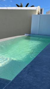 einen Pool mit grünem und blauem Wasser in der Unterkunft Stela caldera view cave/private mini pool/jacuzzi in Akrotiri