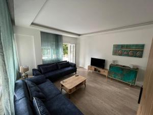 a living room with a blue couch and a table at Antalya’nın nezih semtinde daire in Antalya