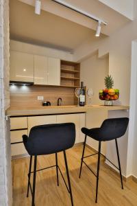 - deux chaises noires dans une cuisine avec un comptoir dans l'établissement Villa La Vida, à Budva