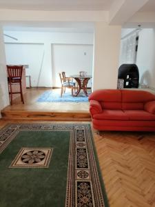 a living room with a red couch and a table at Vila Belashtitsa in Belashtitsa