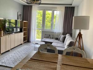 a living room with a couch and a tv at Na rogu 47 in Olsztyn