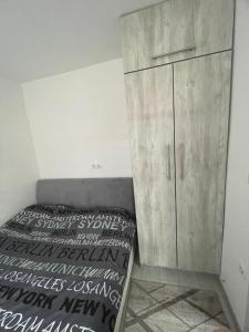 a bedroom with a bed and a wooden cabinet at Mini apartman Smile in Travnik