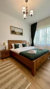 a bedroom with a large bed with a green blanket at Agropensiunea La Gradina in Baia-Sprie