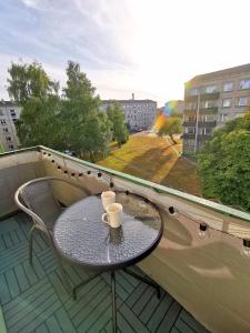 - une table sur un balcon avec deux tasses dans l'établissement Home 4 YOU - self check-in, à Ventspils