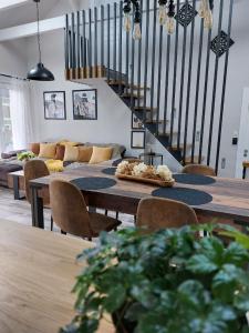 - un salon avec des tables et des chaises et un escalier dans l'établissement Gite & Spa Au pommier fleuri et son "Appart" indépendant, à Drusenheim