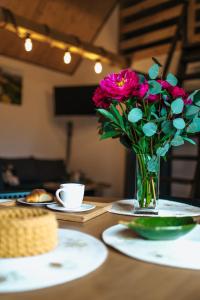 a vase filled with pink flowers sitting on a table at Bieszczadzka Miejscówka in Lutowiska