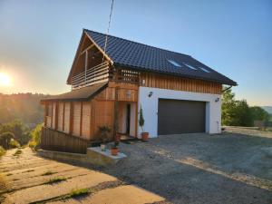 a house with a garage with the sunset in the background at Apartament u Ewki in Rdzawka