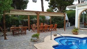 a patio with a hot tub and a table and chairs at Javea VILLA El Nido 10-15p pool 5 autominuten zandstrand Geen groep jongelui in Jávea
