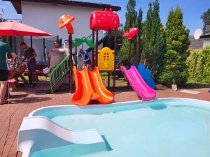 un parque infantil con toboganes coloridos y una piscina en Atlantic aqua resort en Chłopy