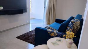 a living room with a blue couch and a table at Apê Bella Vista Campos in Campos do Jordão