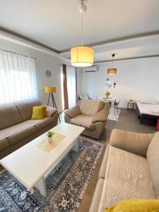 Sala de estar con 2 sofás y mesa en Home Mia 2 bedroom apartment, en Podgorica