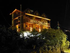 Ein Gebäude mit den Wörtern Adidas Dog City leuchtet nachts in der Unterkunft Adas bungalov Dag Evi in Aralık