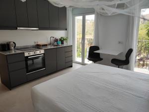 ein Schlafzimmer mit einem Bett und einem Herd sowie eine Küche in der Unterkunft Penthouse Apartment, Cortijo Fruitful HIlls in Málaga