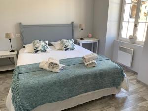 a bedroom with a large bed with towels on it at ESPRIT CAMPAGNE in Montpellier-de-Médillan +16 photos