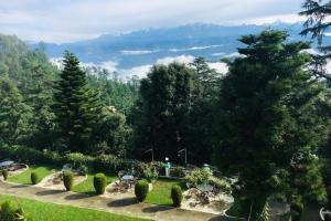 a garden with a view of the mountains and trees at Mountain resort view in Kausani