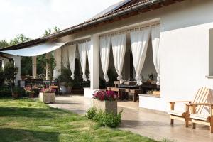 une terrasse avec des rideaux blancs, des tables et des chaises dans l'établissement A Casa di Elena., à Arezzo
