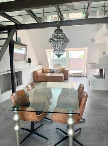 ein Wohnzimmer mit einem Glastisch und einem Sofa in der Unterkunft Schöne Dachgeschoss-Maisonette Wohnung in München