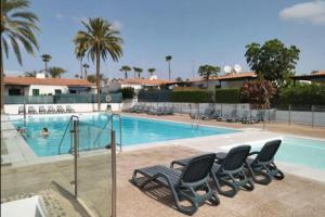 a swimming pool with chairs in a resort at Las Tartanas 110-1-2 in Maspalomas