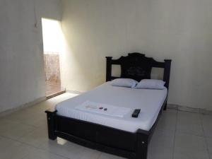 een slaapkamer met een bed met witte lakens en een raam bij Nuevo Hotel La Casita Curumani in Curumaní