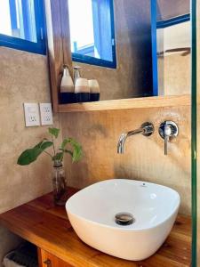 a bathroom with a white sink and a mirror at Casa Omero Garden in El Cuyo