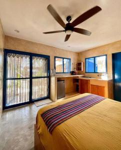 a bedroom with a bed and a ceiling fan at Casa Omero Garden in El Cuyo