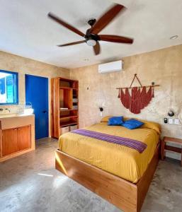 a bedroom with a bed with a ceiling fan at Casa Omero Garden in El Cuyo