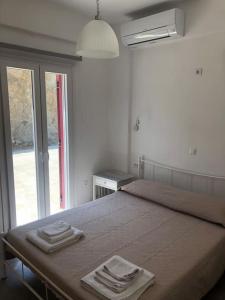卡洛利瓦迪的住宿－Cycladic House with Aegean View，一间卧室配有一张床,上面有两条毛巾