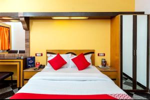 a bedroom with a large bed with red pillows at Hotel Sunpark Inn in Chennai