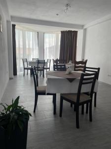 a dining room with tables and chairs and windows at La Scoabă in Baia de Fier