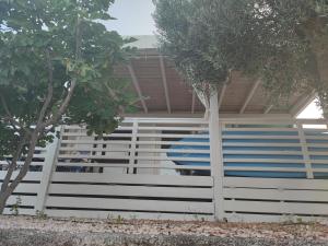 a white fence with a blue surfboard on it at Two Roses Mobile Home in Jezera