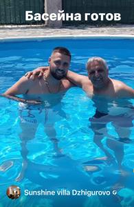 twee mannen in het water in een zwembad bij Sunshine villa Dzhigurovo in Sandanski