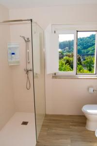 bagno con doccia e finestra di Cantinho do Rio a Ponte da Barca