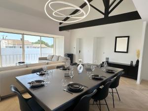 une salle à manger avec une table, des chaises et un lustre dans l'établissement Les appartements du Carnot - Terrasses et Jardins, à La Rochelle