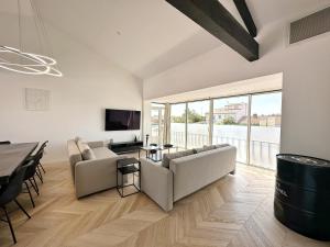 ein Wohnzimmer mit 2 Sofas und einem Tisch in der Unterkunft Les appartements du Carnot - Terrasses et Jardins in La Rochelle