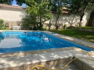 a swimming pool with a hose in a yard at Vila Belashtitsa in Belashtitsa