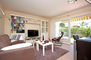 a living room with a couch and a tv and a table at Casa Progreso Costabella in Marbella