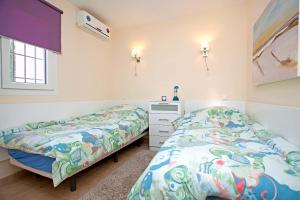 a bedroom with two beds and a dresser at Casa Progreso Costabella in Marbella