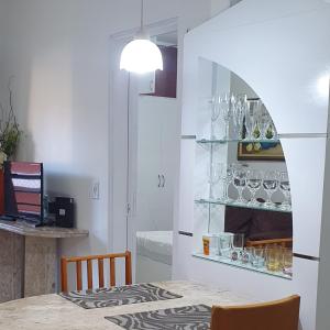 une salle à manger avec une table et une étagère avec des verres dans l'établissement Confortável apartamento a 100 m Beira Mar - Edifício Zen Residence, à Fortaleza