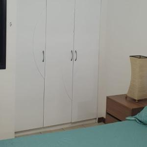 - une chambre avec des placards blancs et une table en bois dans l'établissement Confortável apartamento a 100 m Beira Mar - Edifício Zen Residence, à Fortaleza