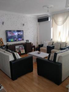 a living room with couches and a flat screen tv at Cozy home in the center of Antalya in Antalya
