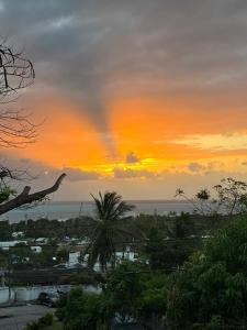 um pôr-do-sol sobre uma cidade com uma palmeira em Apartamento Turistico Soul em La Loma