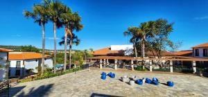 a group of blue chairs on a patio with palm trees at Eco Resort QUINTA SANTA BÁRBARA in Pirenópolis