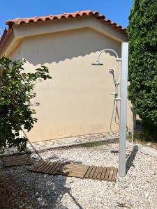 a shower in front of a garage at Villa Kostoula Mini house in Karavomylos