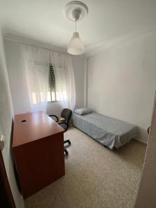 - une petite chambre avec un bureau et un lit dans l'établissement Piso en la puntilla, à El Puerto de Santa María