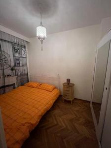 sypialnia z pomarańczowym łóżkiem i żyrandolem w obiekcie Lüx gösterişli mükemmel lokasyon w Stambule