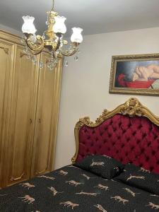 a bedroom with a bed with a red headboard and a painting at Lüx gösterişli mükemmel lokasyon in Istanbul