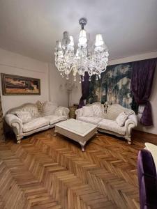 a living room with two couches and a chandelier at Lüx gösterişli mükemmel lokasyon in Istanbul